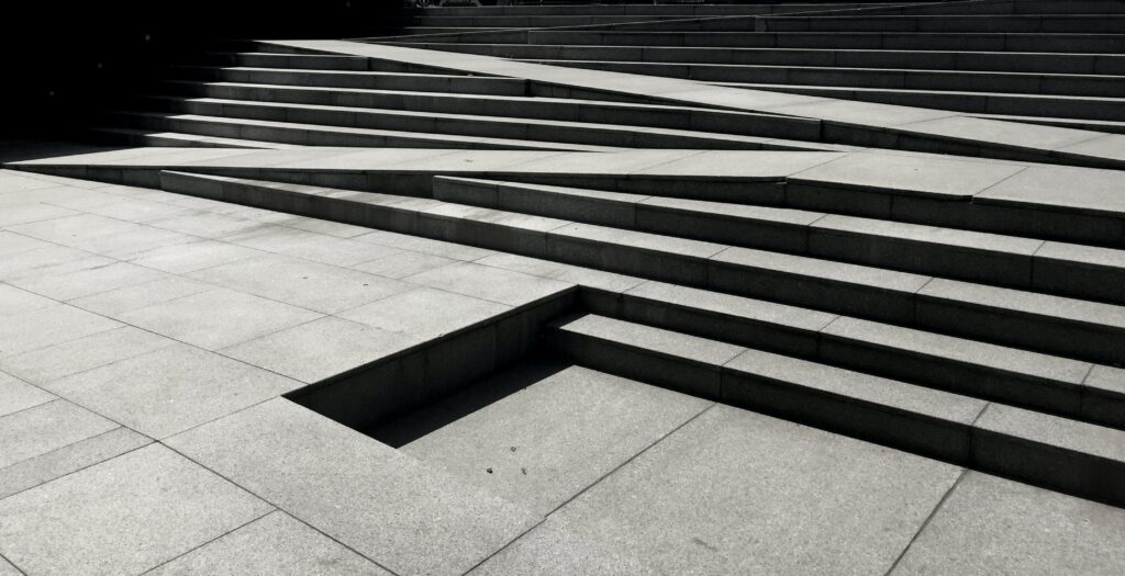 A photograph of a staircase with a zigzagging ramp seamlessly integrated into the same space.